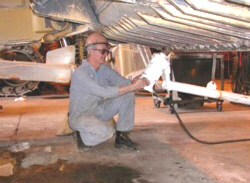 Mechanic uses a support for an impact wrench to reduce exposure to MSD risk factors